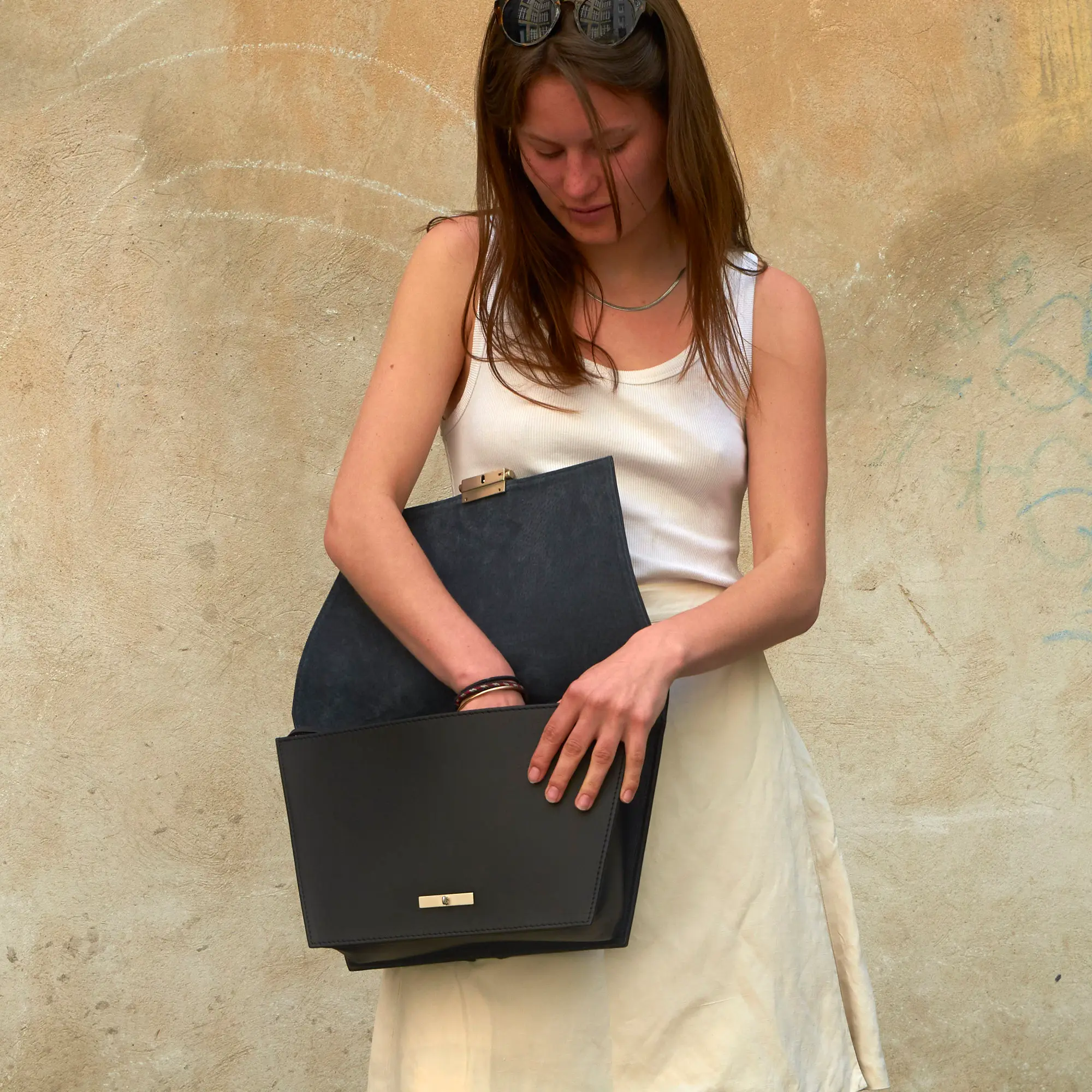 Frau schaut in Olbrish Handtasche Torii, Größe XL, aus schwarzem Nappaleder und Effektleder in Schlangenoptik